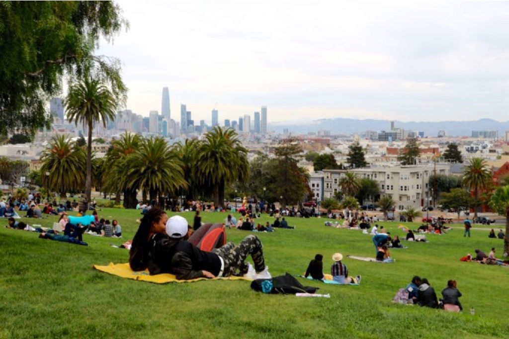 Ragazzi su teli al parco, con sfondo i grattacieli di San Francisco