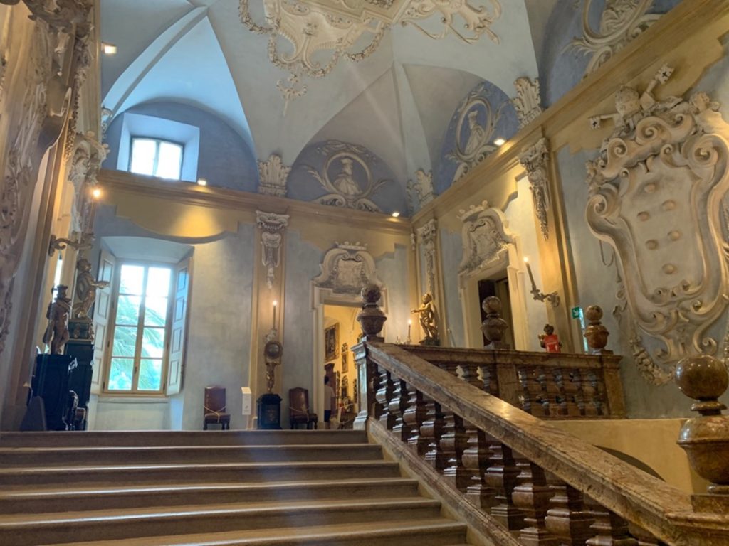 Scalone d'ingresso del Palazzo Borromeo, con pareti azzurre e decorazioni in gesso