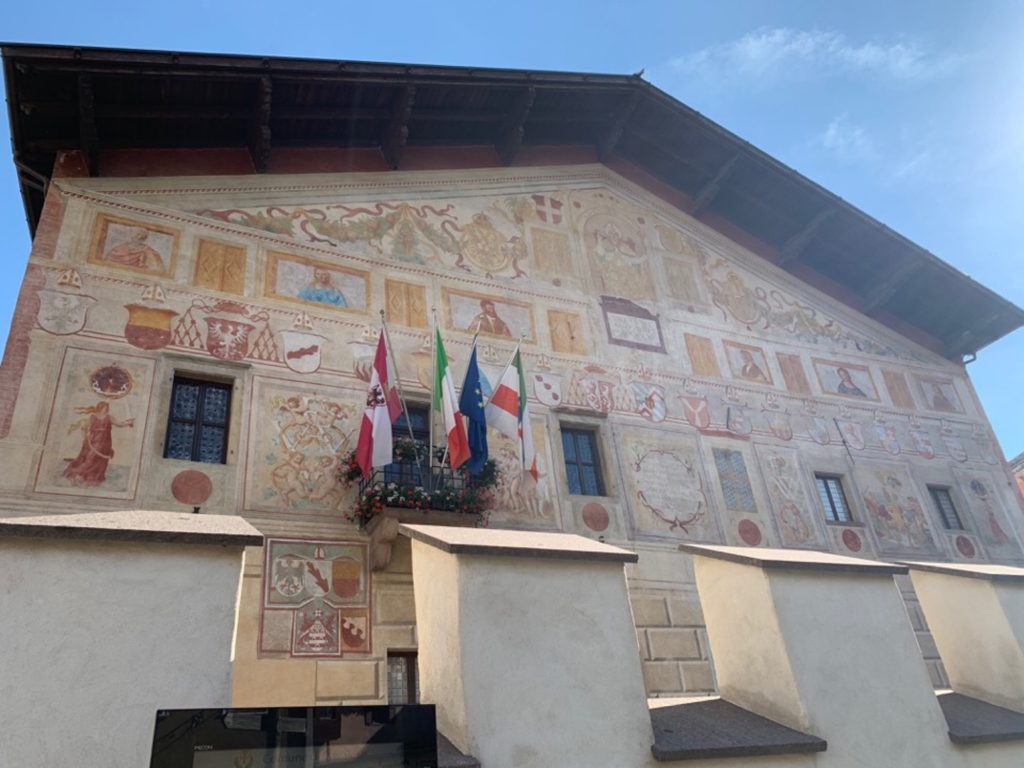 Palazzo affrescato con bandiere a una finestra