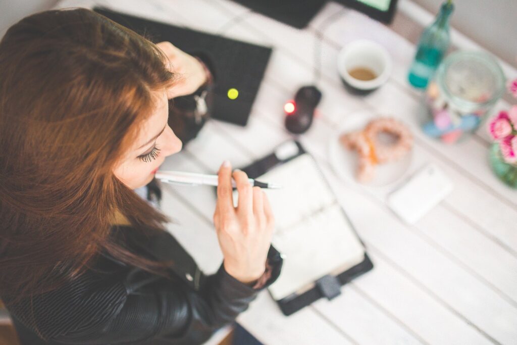 Ragazza che scrive la sua lista dei desideri per i viaggi